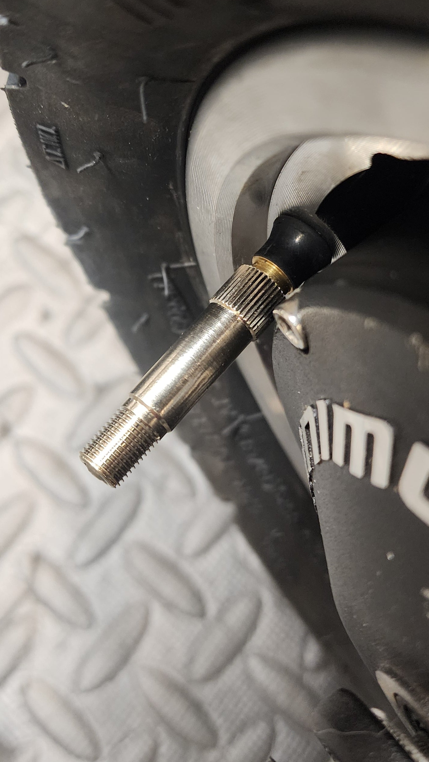 The valve stem of a scooter tire with chrome extension for ease of use