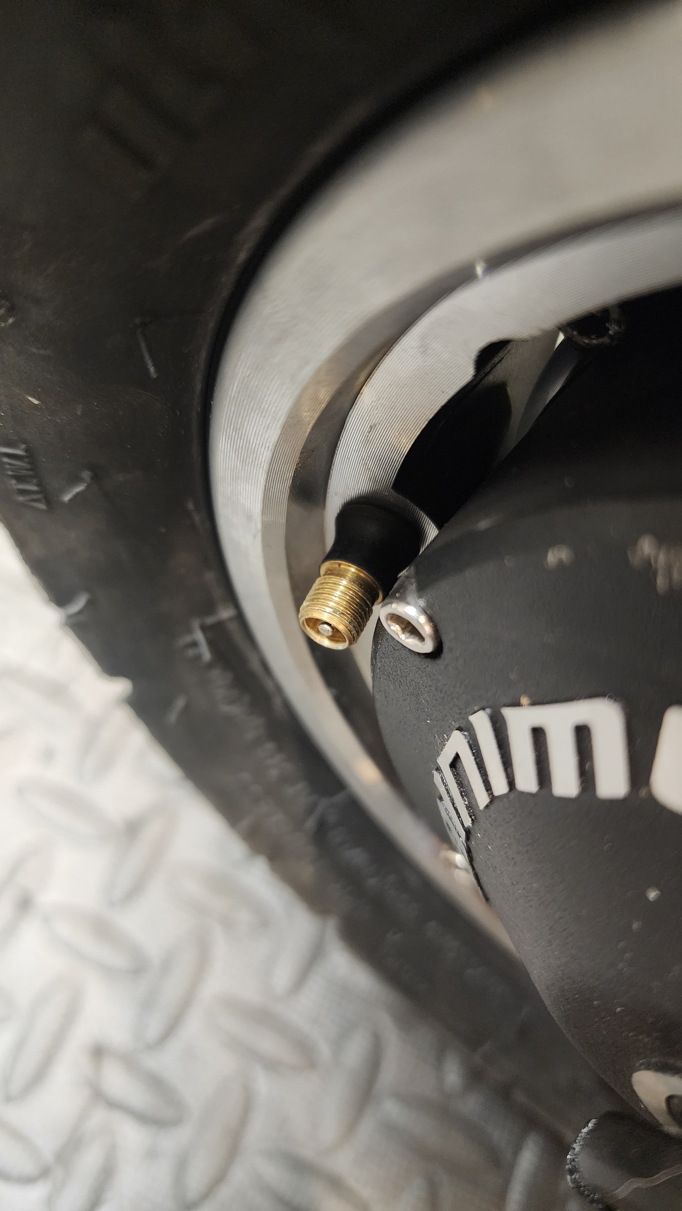 closeup of a standard tubeless tire valve on an electric scooter