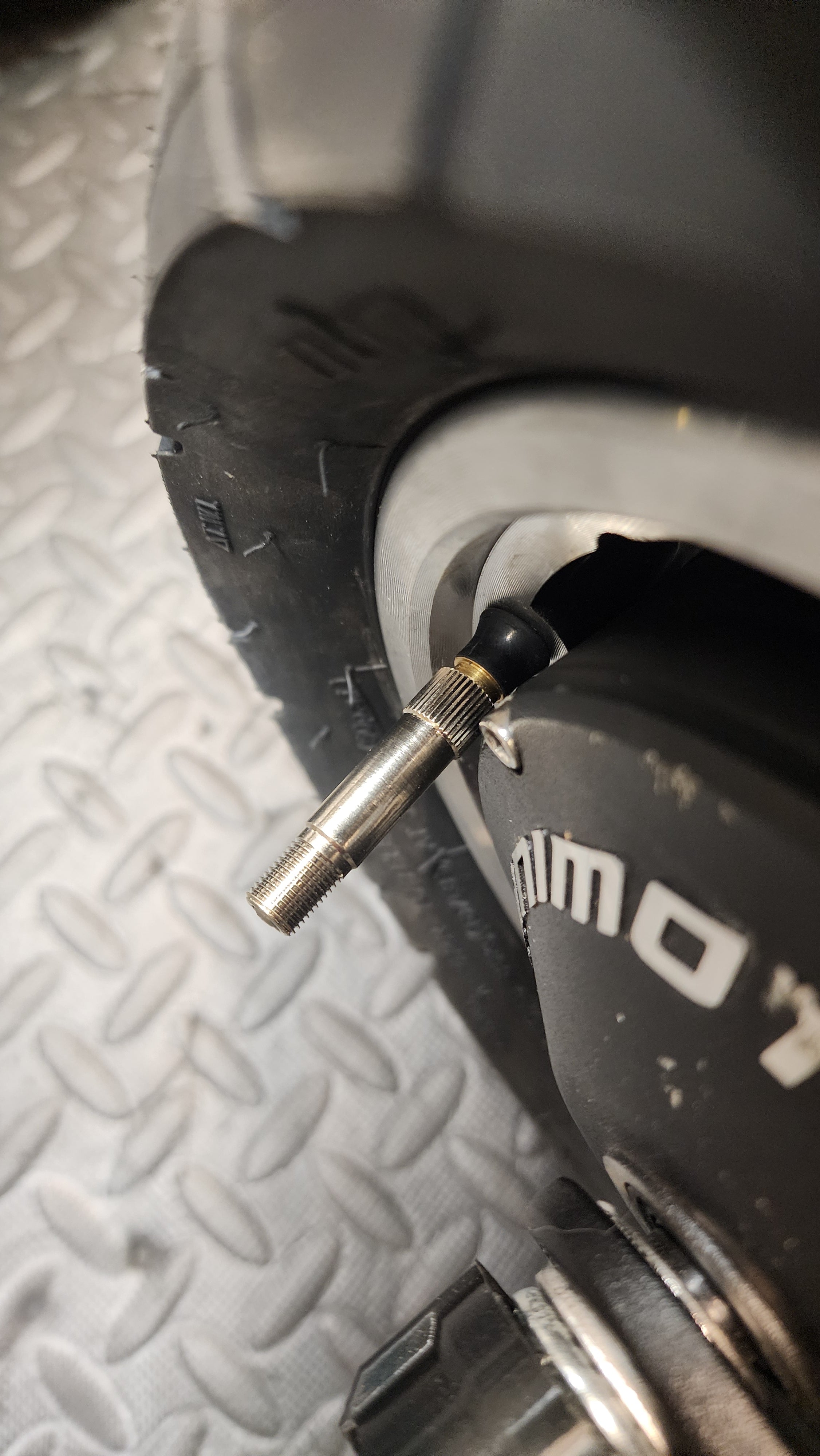 Close-up of a tire valve extension on a vehicle tire.